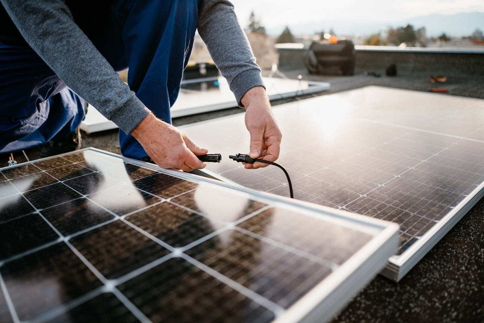 Technik zapojuje fotovoltaický panel na střeše